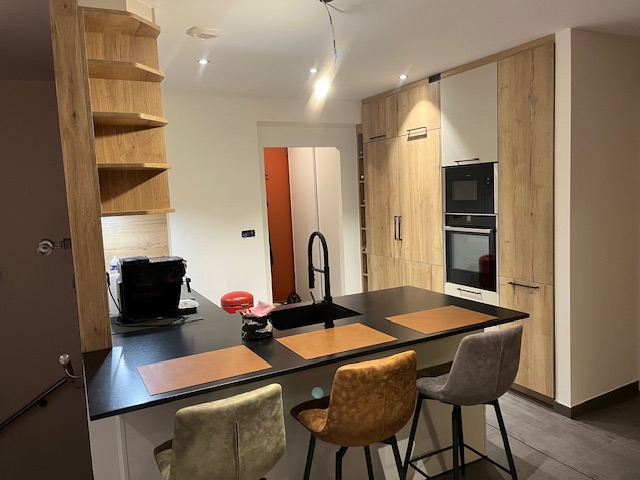 Détail de l’îlot de cuisine avec plan de travail en granit Nero Letano et finitions Rotpunkt à Fontoy