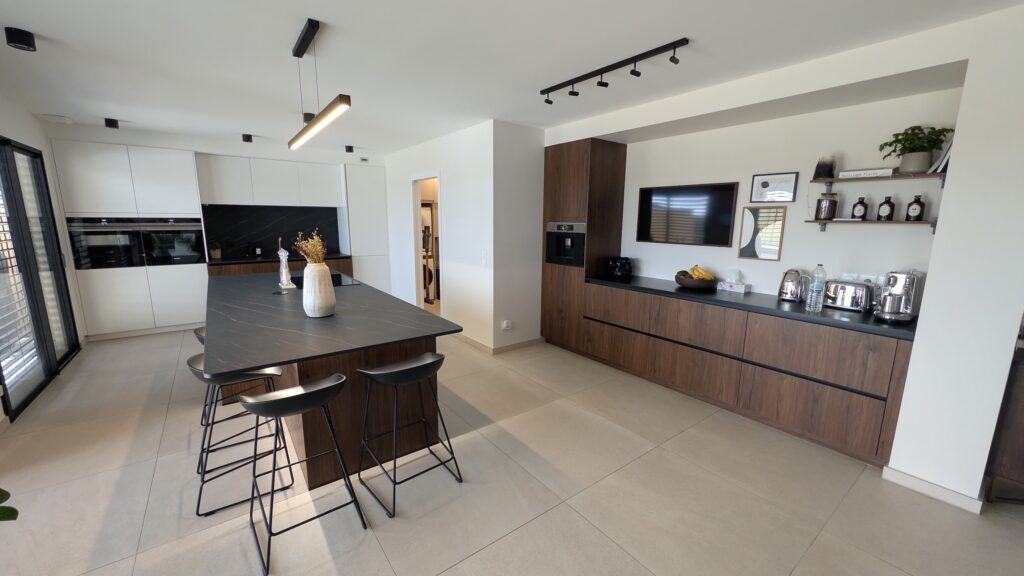 Cuisine contemporaine HÄCKER à Évrange avec mélange noyer et blanc polaire, îlot central et mobilier sur mesure