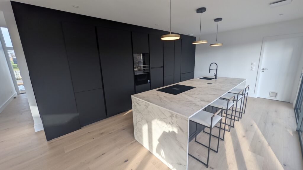 Cuisine contemporaine noire Rotpunkt avec îlot central et espace repas à Fontoy