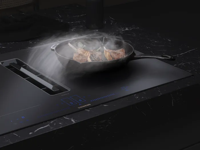 Table aspirante Siemens avec poêle en cuisson dans une cuisine moderne